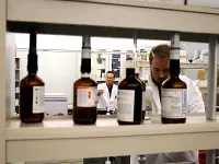 Panoramica di laboratorio di tossicologia con operatori al lavoro e flaconi di reattvi